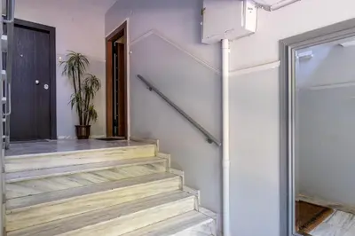 a staircase in a house with a door and a plant at Very comfortable, close to Acropolis in Athens