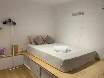 a bed in a room with a white wall at TINY STUDIOS Under the Akropolis -1- in Athens
