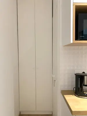 a white cabinet in a kitchen with a microwave at TINY STUDIOS Under the Akropolis -1- in Athens