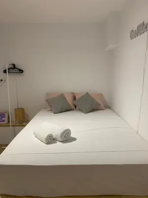 a white bed with two folded towels on it at TINY STUDIOS Under the Akropolis -1- in Athens