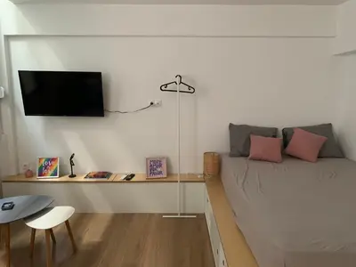 a bedroom with a bed and a tv on a wall at TINY STUDIOS Under the Akropolis -1- in Athens