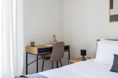 a bedroom with a desk with a chair and a bed at Graceful 2BR Apartment in Paleo Faliro by UPSTREET in Athens