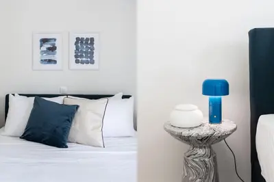 a bedroom with a bed and a blue lamp on a table at Graceful 2BR Apartment in Paleo Faliro by UPSTREET in Athens