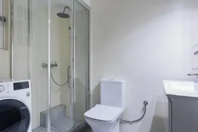 a bathroom with a washing machine and a toilet at Graceful 2BR Apartment in Paleo Faliro by UPSTREET in Athens
