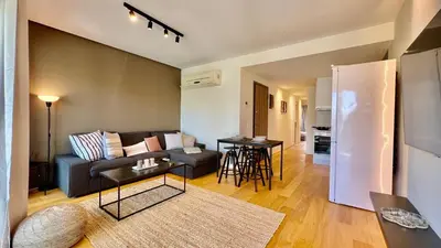 a living room with a couch and a table at Orfeos A2 Modern Retreat in Glyfada in Athens