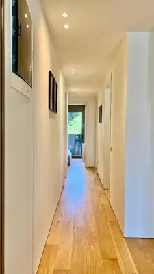 a hallway with wooden floors and white walls at Orfeos A2 Modern Retreat in Glyfada in Athens