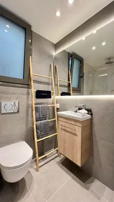 a bathroom with a toilet and a sink and a window at Orfeos A2 Modern Retreat in Glyfada in Athens