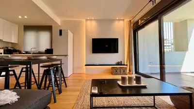 a living room with a couch and a table at Orfeos A2 Modern Retreat in Glyfada in Athens