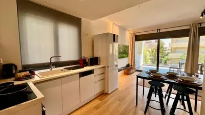 a kitchen with a sink and a table with stools at Orfeos A2 Modern Retreat in Glyfada in Athens