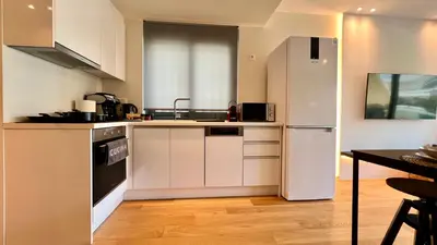 a kitchen with a white refrigerator and a table at Orfeos A2 Modern Retreat in Glyfada in Athens