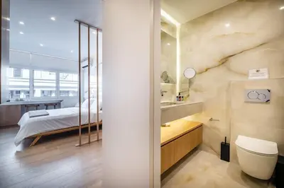 a bedroom with a bed and a bathroom with a sink at Luxurious Studio in the Heart of Athens in Athens