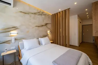 a bedroom with a white bed and a stone wall at Luxurious Studio in the Heart of Athens in Athens