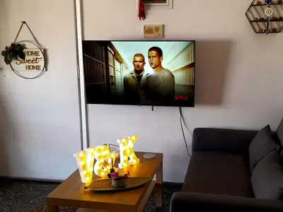 a living room with a flat screen tv on a wall at v&k apartment in Athens
