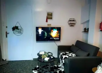 a living room with a couch and a tv on the wall at v&k apartment in Athens