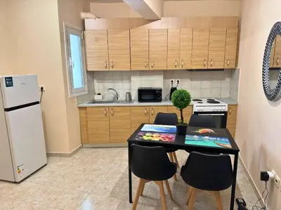 a kitchen with a table with chairs and a refrigerator at Apartment Next to the Metro 100m in Athens