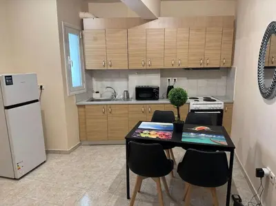 a kitchen with a table with chairs and a refrigerator at Apartment Next to the Metro 100m in Athens