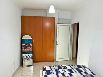 a bedroom with a bed and a wooden cabinet at Apartment Next to the Metro 100m in Athens