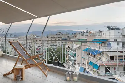 a chair on a balcony with a view of a city at Large terrace studio in Athens