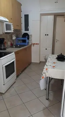 a kitchen with a table and a stove top oven at Cozy and spacious 2 BDR Apt 15 min from the city center in Athens