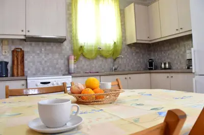 a kitchen table with a bowl of fruit and a cup at Kathrine's Cottage in Vagia in Vaia