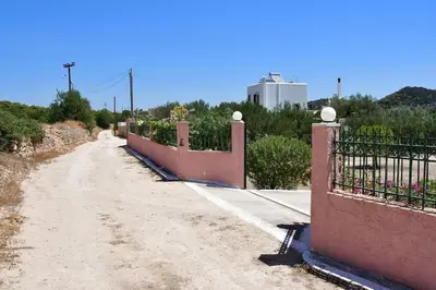 a dirt road with a fence on the side at Kathrine's Cottage in Vagia in Vaia