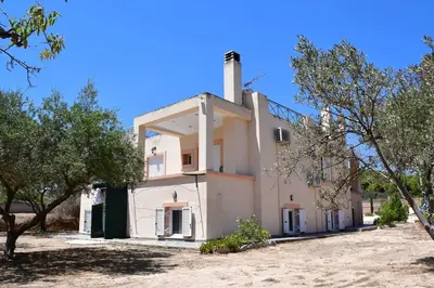 a building with trees in front of it at Kathrine's Cottage in Vagia in Vaia