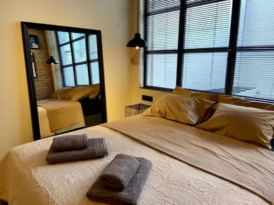 a bedroom with a large bed with a mirror at City Plus by CityBee in Athens