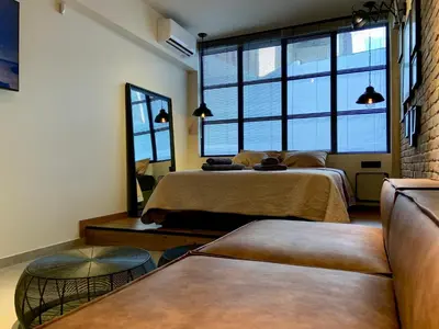 a bedroom with two beds and a large window at City Plus by CityBee in Athens