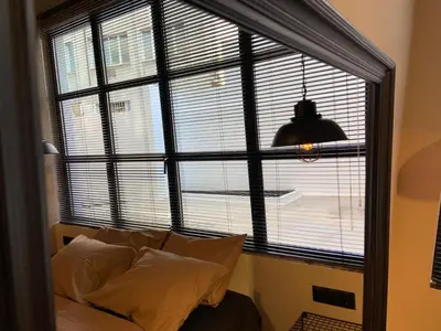 a large window with a couch in front of it at City Plus by CityBee in Athens