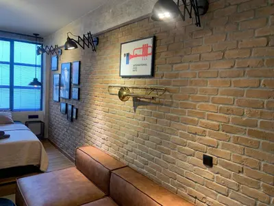 a brick wall with a couch in a room at City Plus by CityBee in Athens