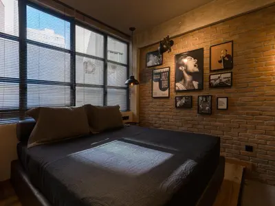 a bedroom with a bed and a brick wall at City Plus by CityBee in Athens