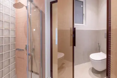 a bathroom with a toilet and a glass shower at Culture Retreat Apartments near Archaeological Museum by Upstreet in Athens