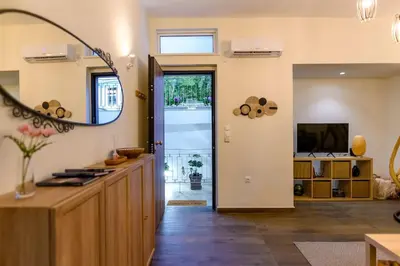 a living room with a large mirror and a kitchen at Kastella Bohemian Pied a Terre in Piraeus
