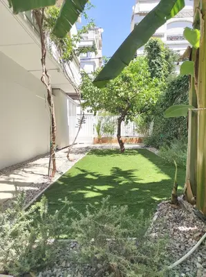 a yard with grass and trees in a building at Viktoria's garden home in Athens