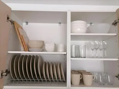 a white cabinet filled with dishes and glasses at Viktoria's garden home in Athens