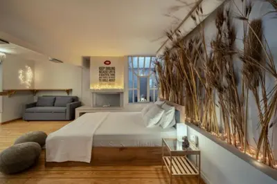 a bedroom with a large bed and a couch at Plastiko Loft in Athens