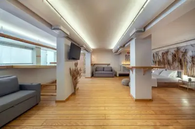 a large living room with a couch and a tv at Plastiko Loft in Athens