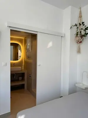 a bedroom with a white bed and a bathroom at Stylish Studio in Psyri in Athens