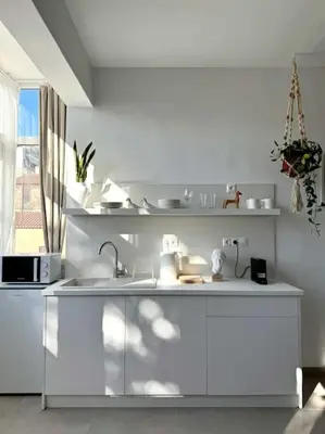 a white kitchen with a sink and a microwave at Stylish Studio in Psyri in Athens