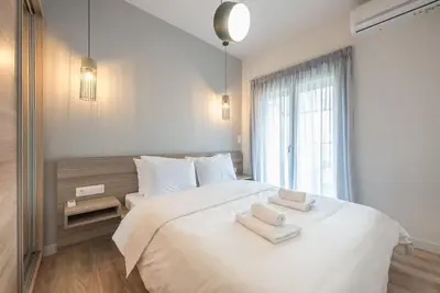 a bedroom with a large white bed with towels on it at Urban Αpartment in Athens