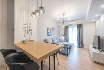 a living room with a dining room table and a couch at Urban Αpartment in Athens