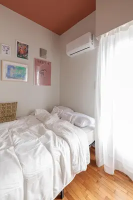 a white bedroom with a bed and a window at Cozy, central studio with expansive balcony in Athens