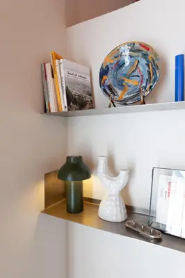 a shelf with books and a lamp and a plate at Cozy, central studio with expansive balcony in Athens