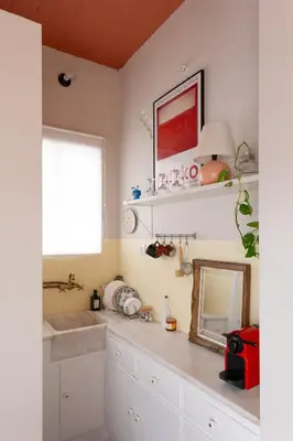 a kitchen with a sink and a mirror and a window at Cozy, central studio with expansive balcony in Athens