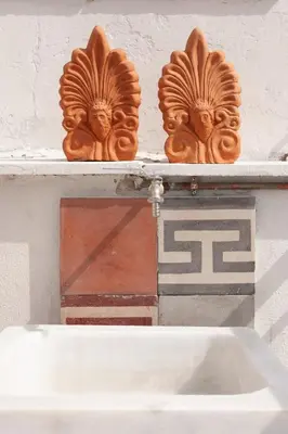 two wooden heads on a shelf above a sink at Cozy, central studio with expansive balcony in Athens