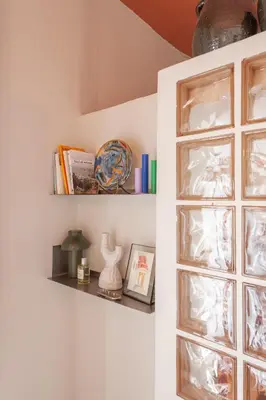 a shelf on a wall with books and vases at Cozy, central studio with expansive balcony in Athens