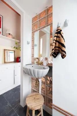 a bathroom with a sink and a wooden stool at Cozy, central studio with expansive balcony in Athens