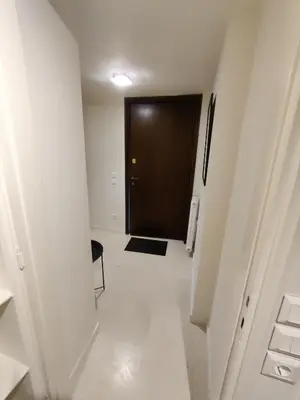 a hallway with a black door and a white floor at Pagkrati Apartment 80 in Athens