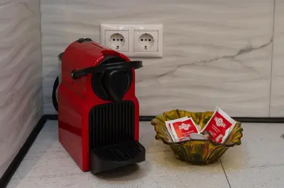 a red suitcase sitting on the floor next to a basket at just for two in Athens in Athens