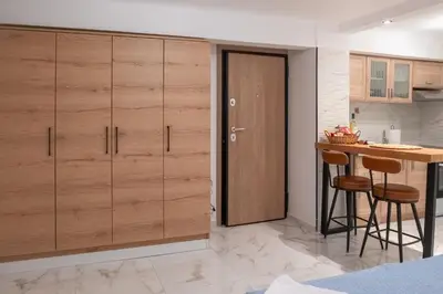 a kitchen with wooden cabinets and a table with stools at just for two in Athens in Athens